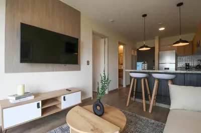 a living room with a couch and a tv on a wall at Benavides by Wynwood House in Lima