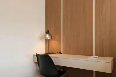 a desk with a chair and a lamp on it at Benavides by Wynwood House in Lima