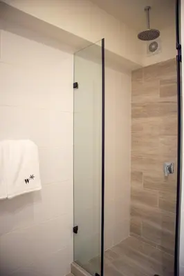 a shower with a glass door in a bathroom at Benavides by Wynwood House in Lima