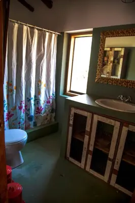a bathroom with a sink and a toilet and a mirror at SAMAY WASI Rest house in Ollantaytambo