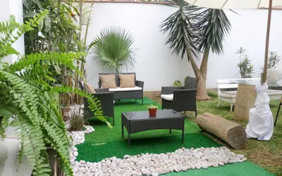 a garden with chairs and a table and plants at 102 habitacion con baño y cocina e ingreso independiente in Lima