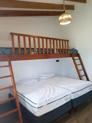 a bedroom with a bunk bed with a ladder at Casa pachacamac in Pachacamac