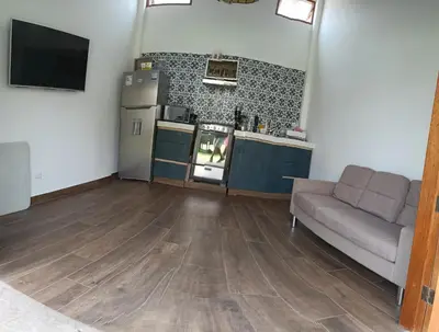 a living room with a couch and a kitchen at Casa pachacamac in Pachacamac
