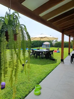 a patio with a table and an umbrella at Casa pachacamac in Pachacamac