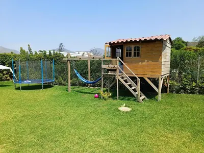 a playground with a play house and a slide at Casa pachacamac in Pachacamac