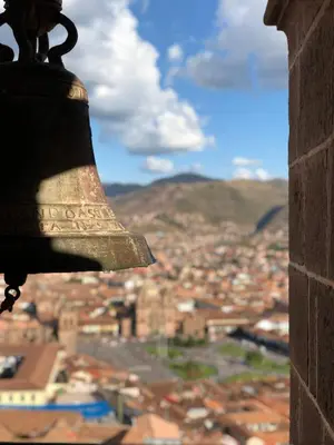 a bell in a tower looking out over a city at The Tree House in Cusco