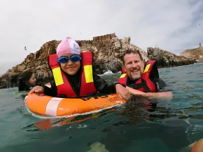 a man and woman in the water in an orange raft at Posada Estela in Lima