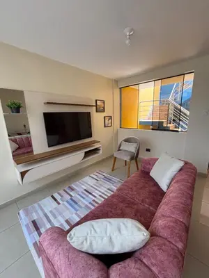 a living room with a couch and a flat screen tv at Light department in Lima