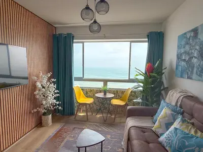 a living room with a couch and a table and chairs at Exclusivo con vista al mar - Blue One in Lima