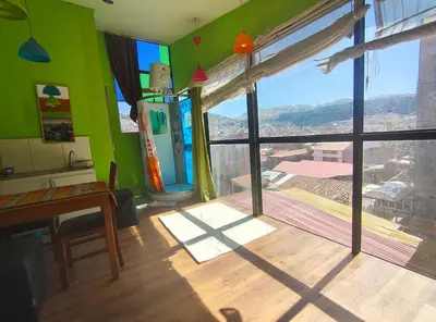 a room with green walls and a large window at IG Art in Cusco