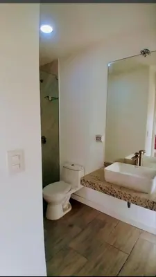 a bathroom with a sink and a toilet and a mirror at Depa en Punta Hermosa in Punta Hermosa