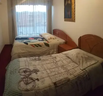 a bedroom with two beds and a bike on the bed at La Casa de mi Abuelo in Cusco