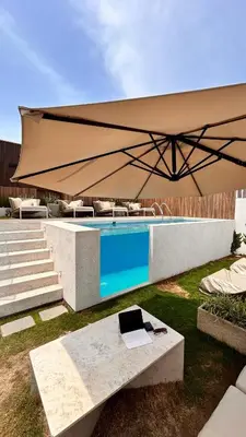 a large tan umbrella next to a swimming pool at Lima Limón in Lima