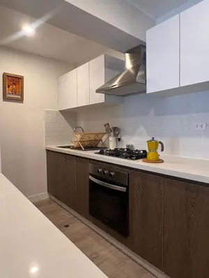 a kitchen with white cabinets and a stove top oven at Lima Limón in Lima