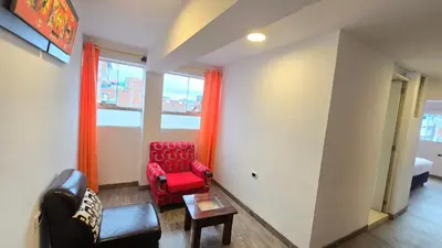 a living room with a red chair and a window at Hotel Cusco Museo in Cusco