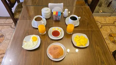 a wooden table with breakfast foods and drinks on it at Hotel Cusco Museo in Cusco