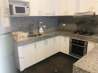 a kitchen with white cabinets and a sink and a microwave at Casa en Asia in Asia