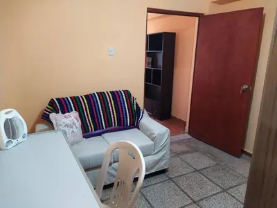 a living room with a couch and a red door at A great experience in the South cone of Lima! in Lima