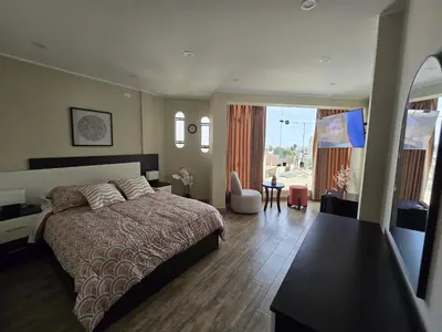 a bedroom with a large bed and a table at Miramar Vip in Barranca