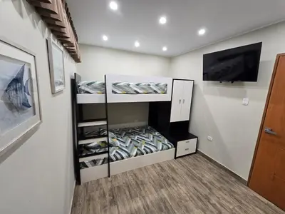 a walk in closet with a tv and shelves at Miramar Vip in Barranca