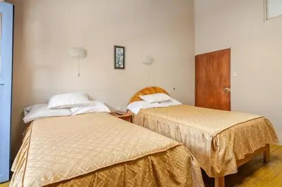 two beds in a hotel room withermottermott at Vista Qoricancha - 2 cuadras Plaza Principal in Cusco
