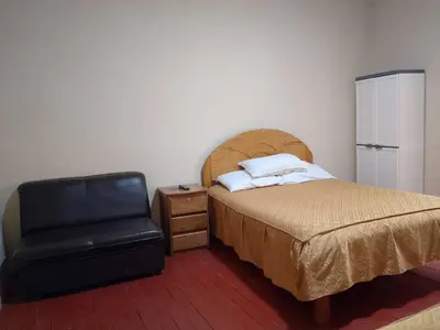 a bedroom with a bed and a black chair at Frente al Qorikancha - 2 cuadras Plaza Central in Cusco
