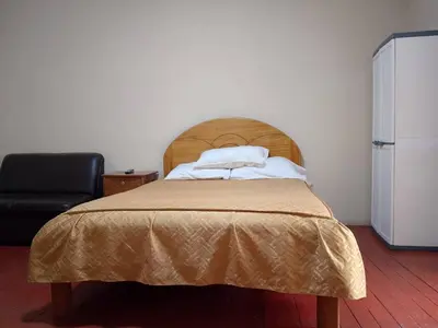 a bedroom with a bed and a black chair at Frente al Qorikancha - 2 cuadras Plaza Central in Cusco