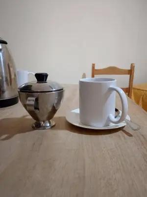 a table with two coffee cups and a bowl on it at Frente al Qorikancha - 2 cuadras Plaza Central in Cusco