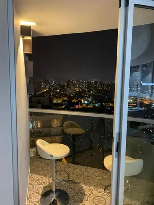 a room with a view of a city at night at Vista piso 24 in Lima