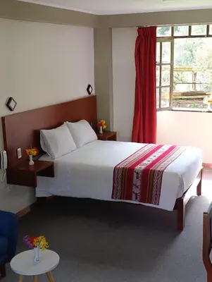 a bedroom with a large bed and a window at Samana House Ollantaytambo in Ollantaytambo