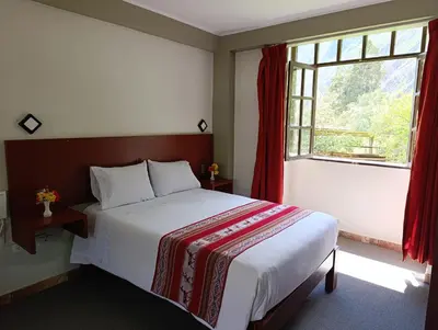a bedroom with a large bed and a window at Samana House Ollantaytambo in Ollantaytambo