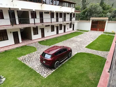 a red car parked in front of a building at Samana House Ollantaytambo in Ollantaytambo