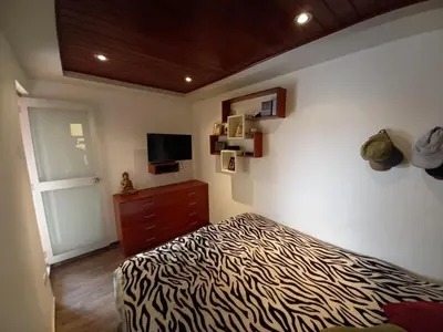 a bedroom with a zebra print bed and a television at Loft Minimalista de Lince in Lima