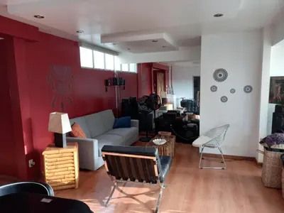 a living room with a white couch and a red wall at Loft Minimalista de Lince in Lima