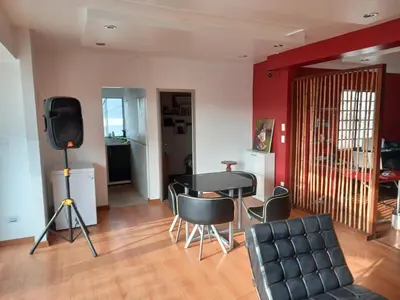 a living room with a table and chairs and a television at Loft Minimalista de Lince in Lima