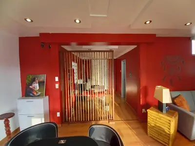 a living room with red walls and a sliding door at Loft Minimalista de Lince in Lima