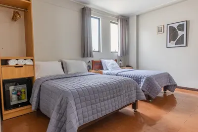 a bedroom with two beds and a fireplace in it at San Miguel Awanka Hotel in Lima
