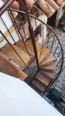 a metal and wood spiral staircase in a building at Antuquita's House in Cusco