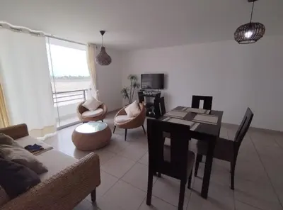 a living room with a table and chairs and a dining room at Duplex con piscina en Asia in Asia