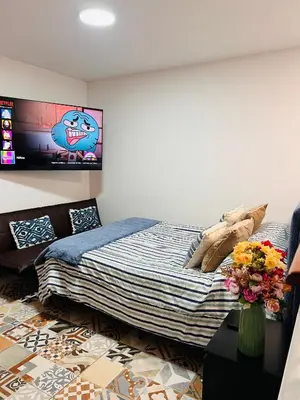 a bedroom with a bed and a tv on the wall at MONTERRICO POLO APARTS #8 - Dpto de 2 camas Frente Embajada de USA con AC in Lima