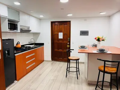 a kitchen with a counter and two stools at MONTERRICO POLO APARTS #8 - Dpto de 2 camas Frente Embajada de USA con AC in Lima