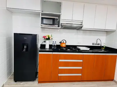 a kitchen with a black refrigerator and a microwave at MONTERRICO POLO APARTS #8 - Dpto de 2 camas Frente Embajada de USA con AC in Lima