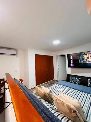 a bedroom with a bed and a tv on the wall at MONTERRICO POLO APARTS #8 - Dpto de 2 camas Frente Embajada de USA con AC in Lima
