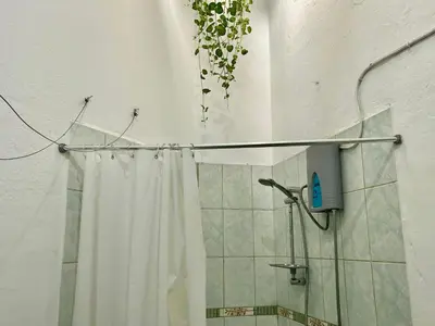 a shower with a white shower curtain in a bathroom at Entire House close to the sea Miraflores in Lima