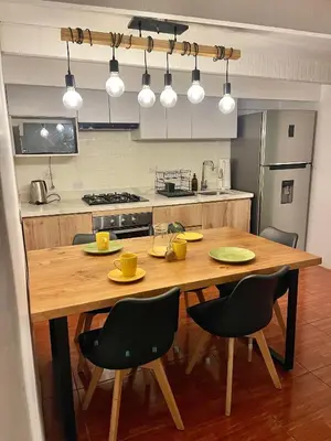 a kitchen with a wooden table and black chairs at Entire House close to the sea Miraflores in Lima