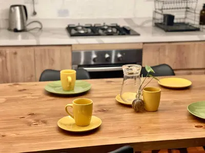 a wooden table with yellow cups and plates on it at Entire House close to the sea Miraflores in Lima