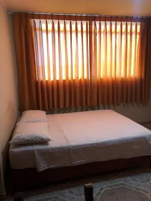 a bed in a room with a large window at Hospedaje Monumental in Chincha