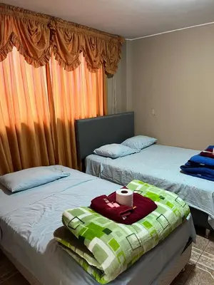 a bedroom with two beds and a window at Hospedaje Monumental in Chincha