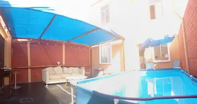 a large swimming pool in a building with a couch at Sweet Rustic Home in Hacienda Santo Domingo