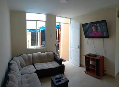 a living room with a couch and a flat screen tv at Sweet Rustic Home in Hacienda Santo Domingo